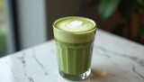 "A matcha latte with a latte art, in a glass jar, on a marble countertop, soft lighting"