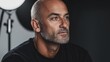 © Lifestyle Images - Close-up portrait of a middle-aged man with a bald head and a goatee. he is wearing a black t-shirt and is looking off to the side with a serious expression on his face.