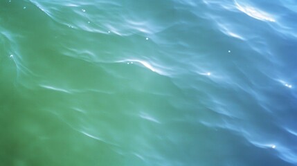 Poster - A tranquil view of shimmering green and blue water, capturing the gentle movement and reflections on the surface.