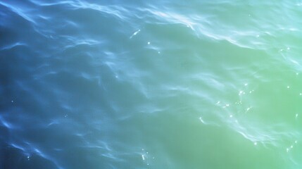 Poster - A serene view of shimmering water with gentle waves, showcasing a gradient of blue and green hues under soft light.