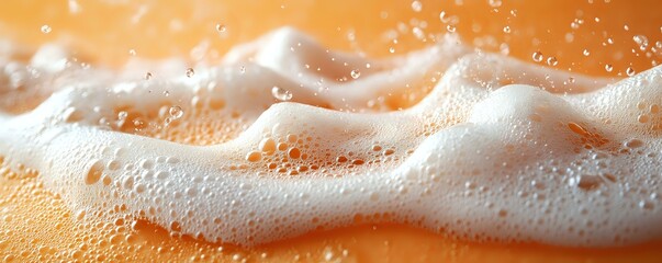 Poster - Flowing white foam and bubbles on orange liquid surface creates dynamic texture with splashing droplets and frothy waves in macro photography.