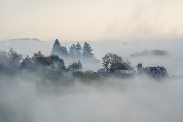 Wall Mural - aerial landscape with fluffy morning mists over the picturesque, autumn-covered rolling hills and th