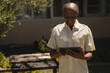© WavebreakMediaMicro - Elderly man enjoying sunny day while reading on digital tablet outdoors, copy space