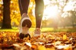 © oksa_studio - Close-up of running shoes walking on fallen autumn leaves in a park, enjoying sunlight