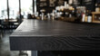 © JosCarlosdaSilva - Dark wooden table top with blurred background of a coffee shop or bar interior.