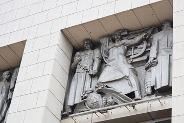 Aufkleber - A statue sits on the side of a building, adding a touch of elegance and character.
