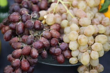 Aufkleber - A cluster of red and green grapes sits atop a wooden or glass table surface.