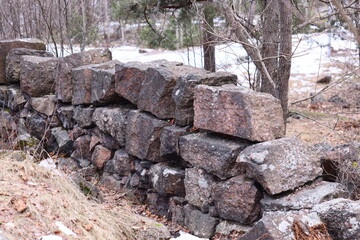 Poster - A natural stone wall amidst dense foliage, suitable for outdoor scenery and environmental contexts.
