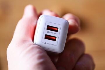 Aufkleber - A person holds a small white device in their hand, possibly a phone or tablet.