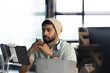 © Wavebreak Media - Focused man in beanie working on tablet at modern office desk