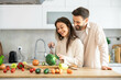 © Dejan - A couple enjoys cooking together while smiling, surrounded by fresh vegetables in a bright kitchen setting, perfect for meal prep.