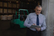 © Wavebreak Media - Businessman in warehouse writing on clipboard, focusing on inventory management, copy space