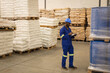 © Wavebreak Media - Warehouse worker in blue uniform inspecting inventory and taking notes on clipboard, copy space
