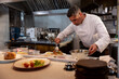 © Wavebreak Media - In kitchen, chef preparing gourmet dish, focusing on presentation and flavor, copy space