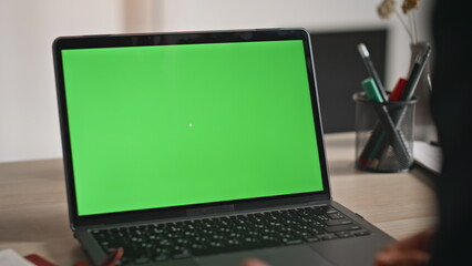 Wall Mural - Employee watching green screen laptop at workplace closeup. Hands pressing key
