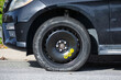 © MichaelVi - Temporary spare tire with yellow speed limit and inflation pressure markings on a black car parked on a road
