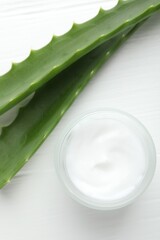 Wall Mural - cream and aloe leaves on white wooden background, flat lay