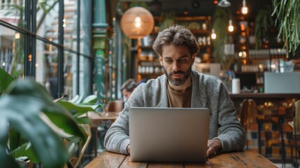 Poster - Freelancer focuses on work in a remote cafe with laptop while enjoying a cozy atmosphere during the day