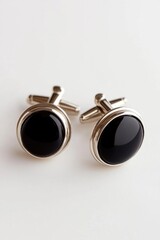Poster - A close-up shot of a pair of black cufflinks on a white background, perfect for use in jewelry or fashion-related contexts