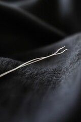 Poster - A pair of scissors placed on a dark colored cloth