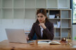 © Jirapong - female attorney advisor at a law firm reviews legal documents at her desk equipped with a laptop notebook and scales of justice in the office