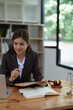© Jirapong - female attorney advisor at a law firm reviews legal documents at her desk equipped with a laptop notebook and scales of justice in the office