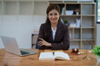 © Jirapong - female attorney advisor at a law firm reviews legal documents at her desk equipped with a laptop notebook and scales of justice in the office