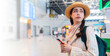 © _KUBE_ - Portrait of a beautiful young Caucasian woman in a straw hat and jacket holding passport with a boarding pass for flight. Web banner of travel and trip with copy space