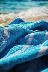 Poster - A close-up view of a towel lying on a sandy beach, perfect for outdoor activities or travel