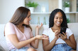 © Antonioguillem - Black woman using phone ignoring her friend