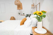 © Pixel-Shot - Interior of light bedroom with cozy bed and beautiful sunflowers on bedside table