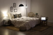 © Pixel-Shot - Interior of modern bedroom with cozy bed, laptop and glowing lamps at night