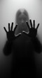 © Stock Monster - A blurry black-and-white photo of two hands behind foggy glass, creating an eerie atmosphere