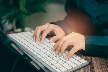 Poster - Person Typing on Keyboard in Modern Workspace with Green Plant in Background for Productivity, Business concept