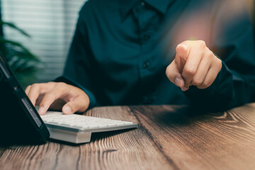 Poster - Business Person Pointing Finger at Screen While Working on Laptop in Modern Office Setting, Business concept
