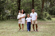 © Austockphoto - Happy family walking on the grassy field of the public park.