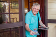 © Austockphoto - Old person at front door handing over cash from wallet