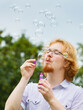 © Voyagerix - Man blowing soap bubbles, having fun