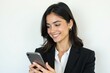 © JetHuynh - A young, attractive businesswoman in a black suit smiles confidently while holding a smartphone. She projects success and professionalism.