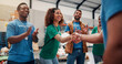 © peopleimages.com - Clapping, handshake and support with volunteer team in warehouse together for aid, community or welfare. Applause, charity and donation with people shaking hands for ngo or non profit success