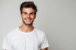 © NikoG - Portrait of a handsome young man in white t shirt smiling while standing against white background