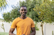 © Wavebreak Media - Smiling man in orange shirt enjoying sunny day outdoors in lush garden