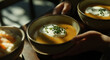 © Vitor - Deliciosa sopa cremosa de cenoura caseira guarnecida com uma colherada de creme ou iogurte e cebolinhas frescas, servida em tigelas e lindamente capturada em luz natural com foco seletivo