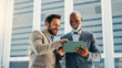 © peopleimages.com - Business people, tablet and men in city, smile or conversation with profit growth. Happy employees, financial consultant or tax advisor with tech, website info or email for company review in New York