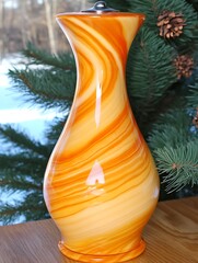 Poster - Elegant orange swirl glass vase amidst winter greenery home decor scene