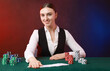 © New Africa - Professional croupier with casino chips and playing cards at gambling table on color background with smoke