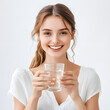 © Alona - A cheerful young woman smiles broadly while holding a glass of water, radiating positivity.