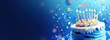 © Boke - Delicious blue birthday cake with lit candles and falling confetti on blue background