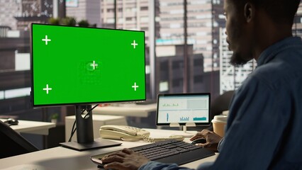 Poster - male administrator focused on financial planning next to chroma key screen, reviewing infographics f