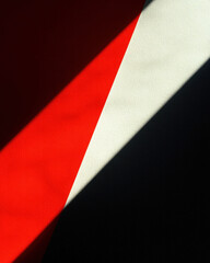 Poster - A black and white photo of a red and white striped fabric. The photo is of a shadow cast on the fabric